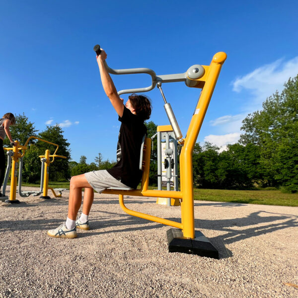 Homme utilisant un matériel de fitness extérieur