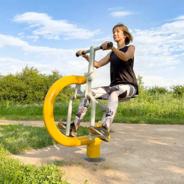 femme utilisant un cavalier de fitness extérieur