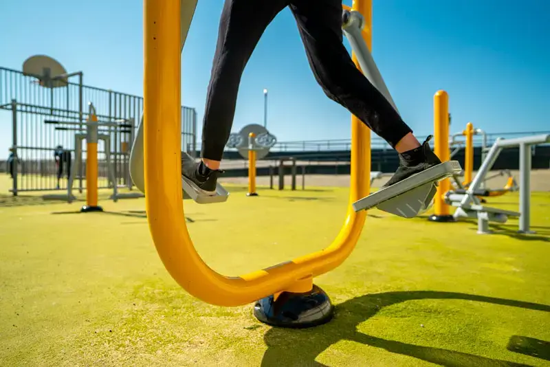 Personne utilisant un marcheur conforme aux normes fitness extérieur