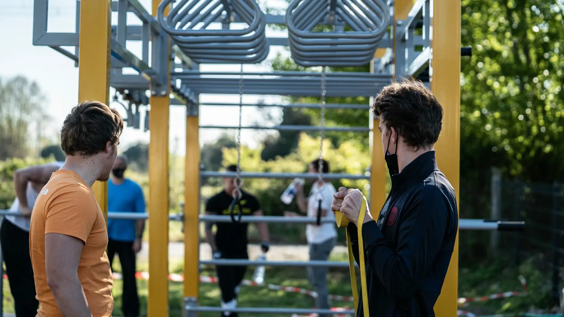 pratiquants de street workout sur une aire de fitness extérieur conforme à la norme en16630