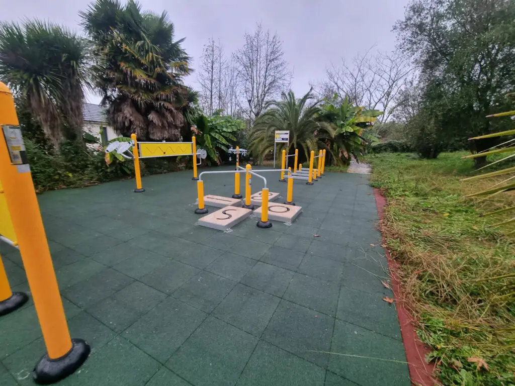 Aire de fitness extérieure avec appareils fitness Sénior / PMR au parc de Thèse, entourée de végétation tropicale.